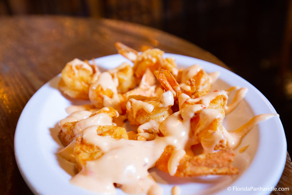 tempura fried shrimp with creamy sauce on top inside of white bowl at boon docks