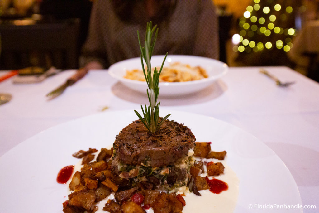 stuffed steak with a stick of rosemary on top and home fries on the side at Firefly 
