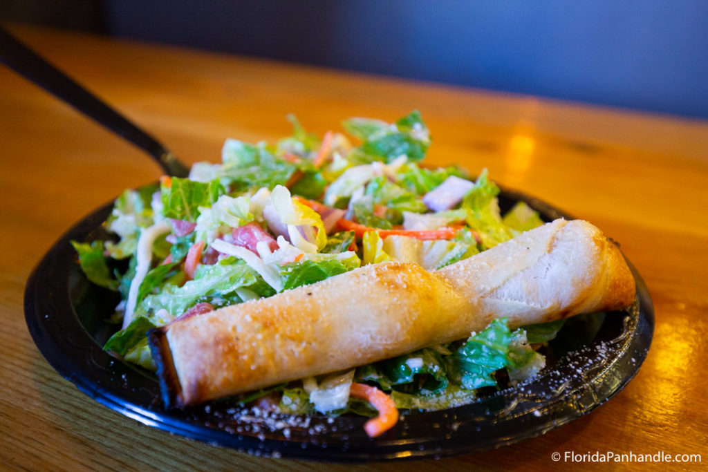 a plate of salad with a side of bread