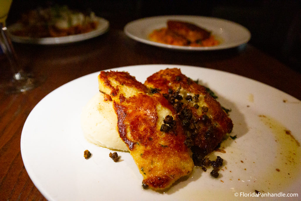 Golden fried fish on top of mashed potatoes at The Grand Marlin Restaurant and Oyster Bar in Panama City Beach