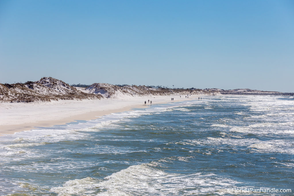 people walking on white sandy beach in Panama City Beach