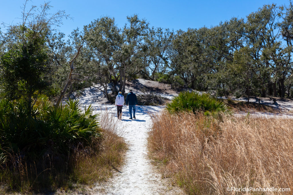 a couple walking along a sandy trail