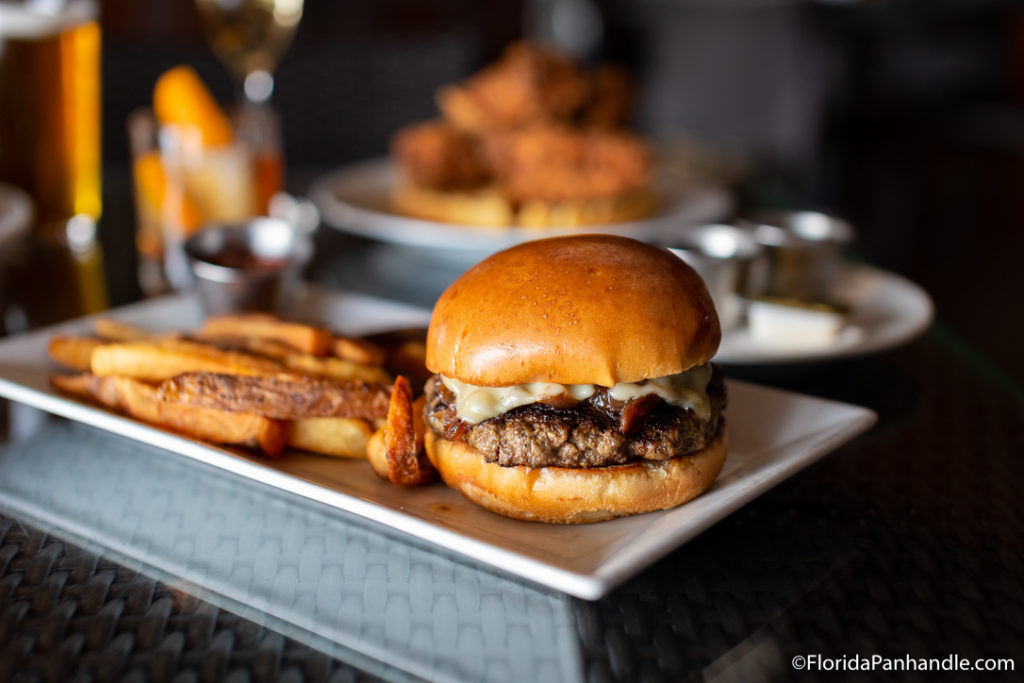 a cheesy burger with bacon with a side of fries at Craft Bar 