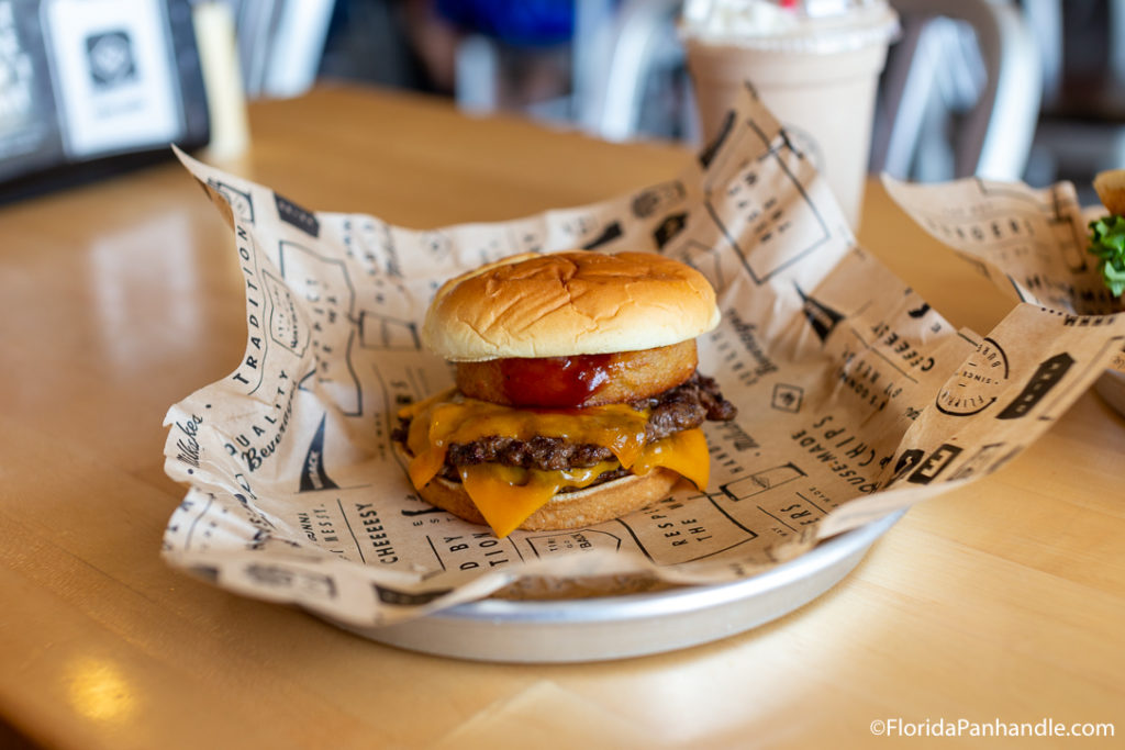 a cheesy burger with a onion ring in it at Wayback