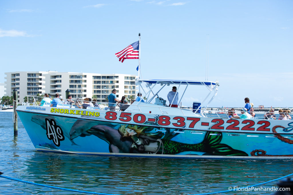 a large boat with a picture of a mermaid on the side and big red numbers with a group of people on it