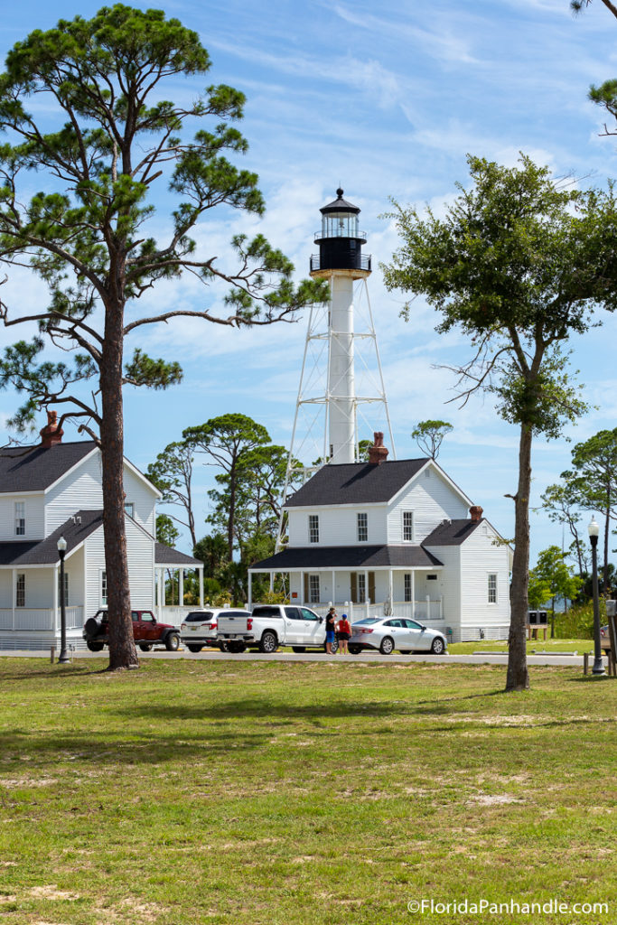 a lighthouse and white houses around it 