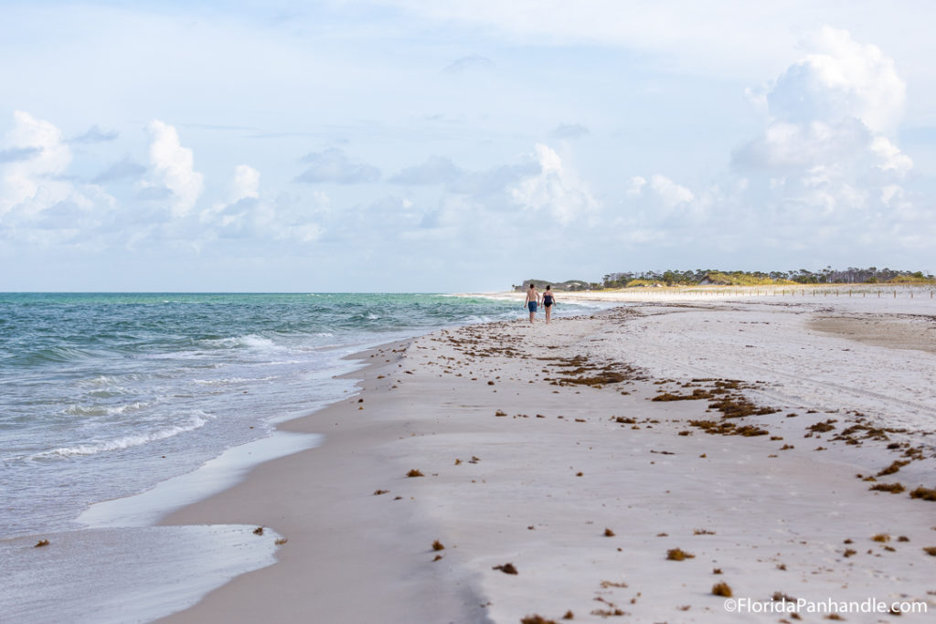 two people walking along the beach