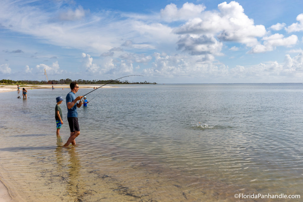 father and son standing in the water as they fish