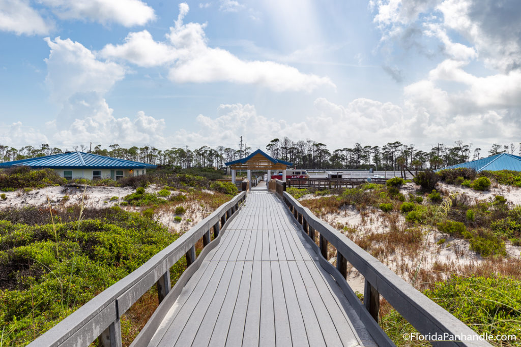 a wooden walkway leading to a lake 