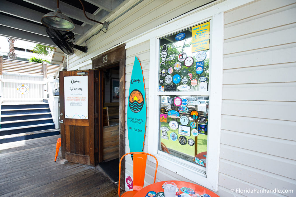 exterior of chiringo in 30a with surfboard out front and stickers on window