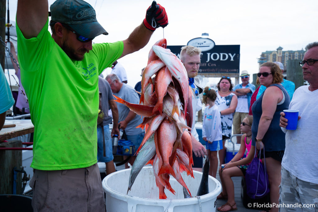 man holding up a bunch of fish