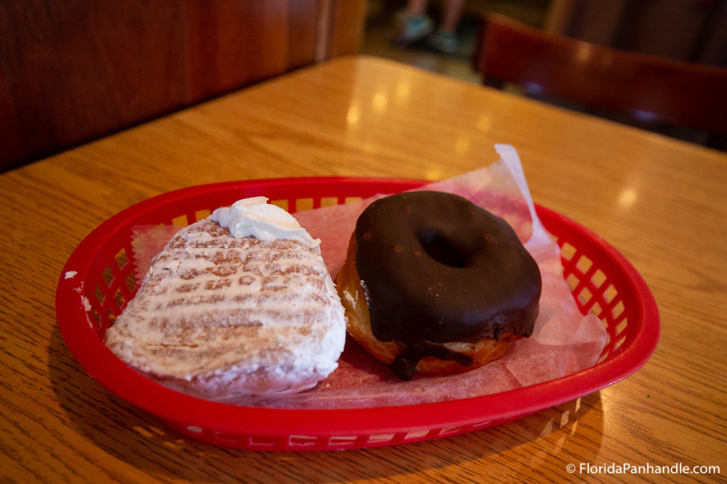 a powder cream filled donut and a chocolate frosted donut