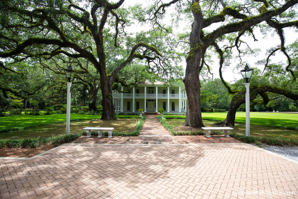 a pathway in between two trees to a two story house at Eden Gardens State Park