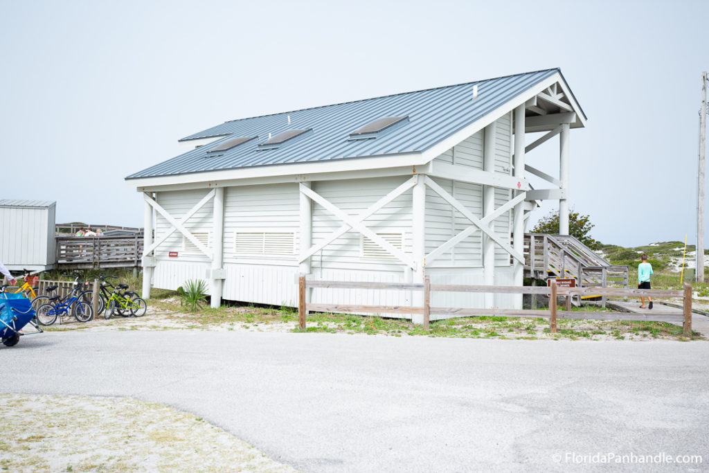white wooden shed on top of grass area at grayton beach
