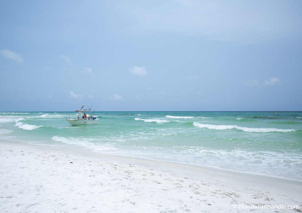 a boat in the water at the beach close to the shoreline during the day