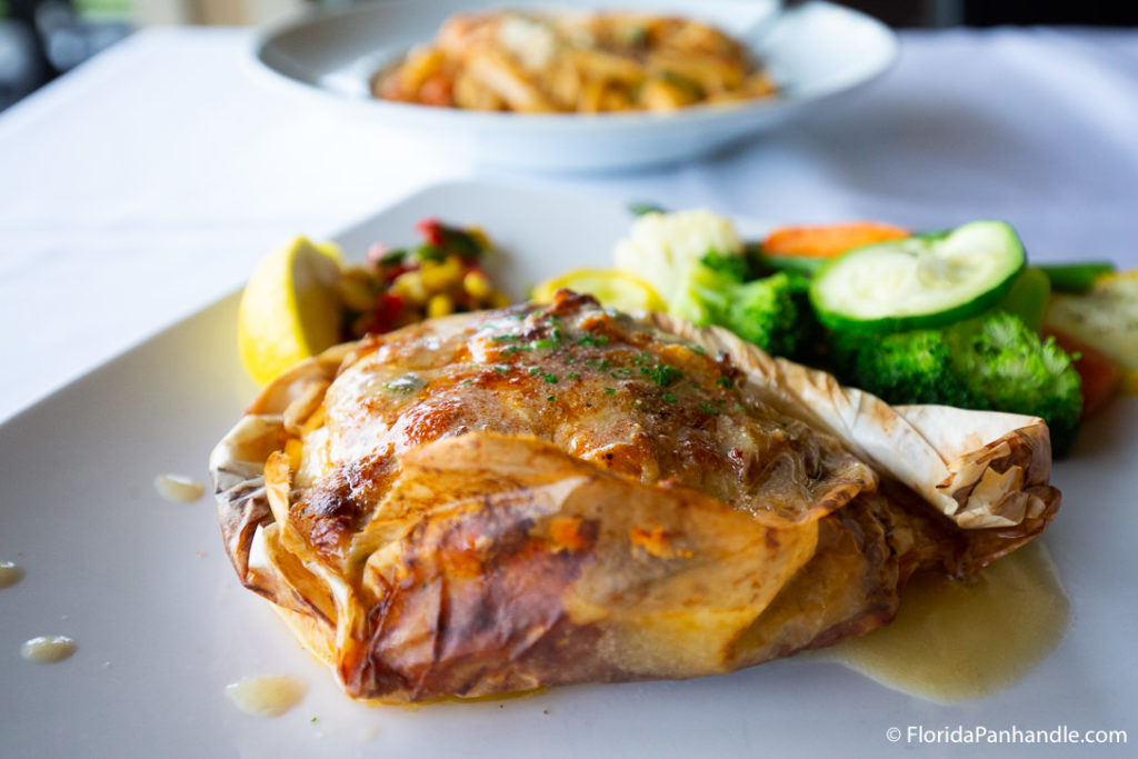 chicken next to lemon, corn, and veggies at louisiana lagniappe in destin fl