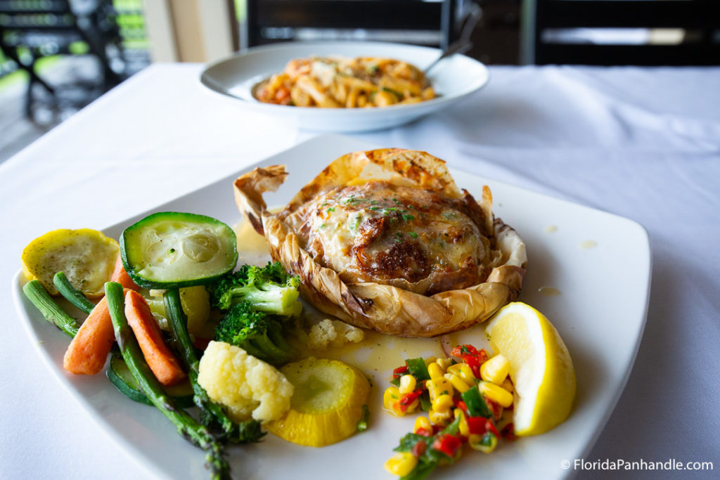 a baked potato with a side of veggies at Louisiana Lagniappe