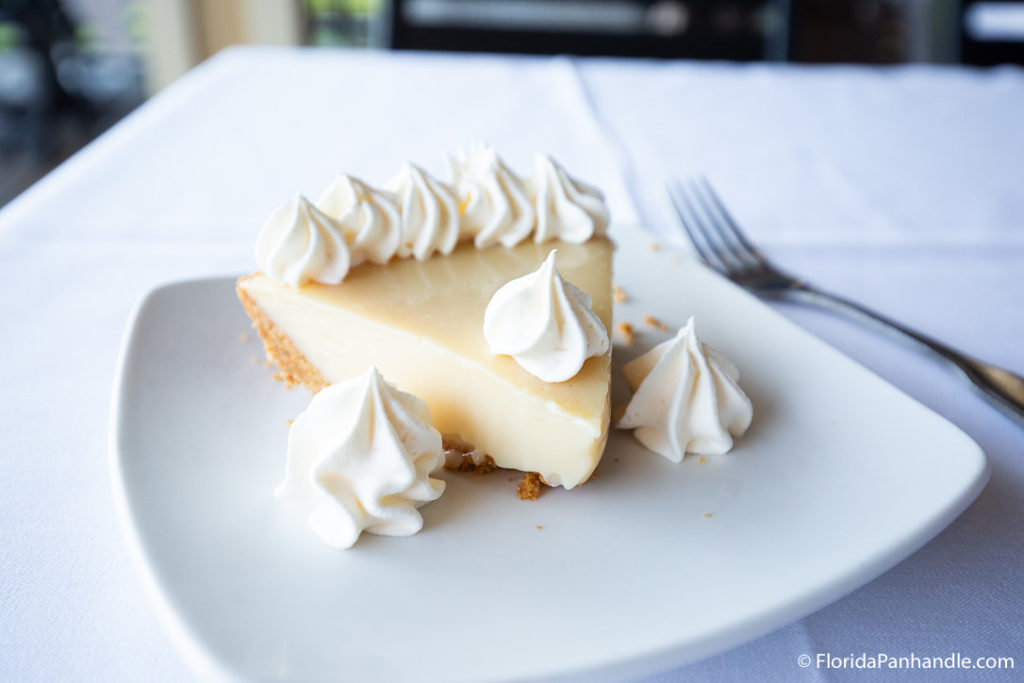 a slice of key lime pie with dollops of whipped cream on top