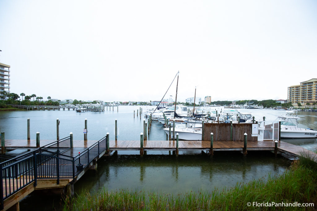 view of the wooden pier on the water with white boats docking at it