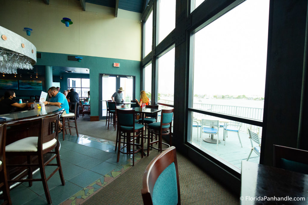 a dining area with big windows, beachside restaurant in destin