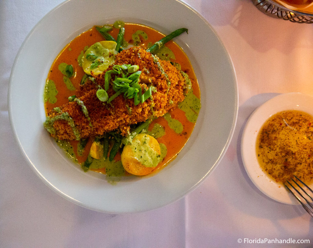 fried fish on a bed of green beans and sliced yellow zucchini