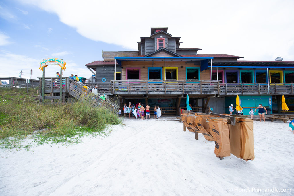 a wooden building with colorful outlining on the beach