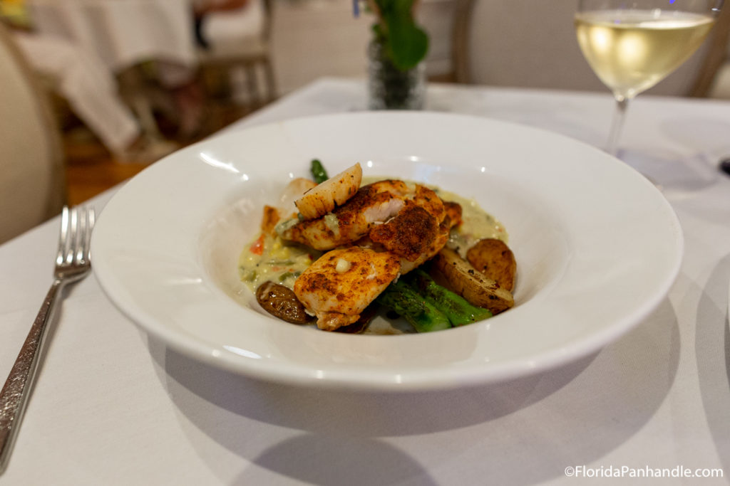 a plate of grilled chicken on a plate of green beans with mushroom and a veggie puree at Beach Walk Cafe