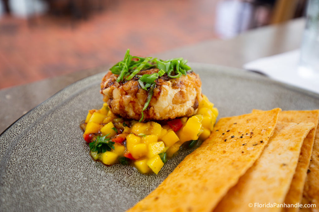 small crab cake on top of small chopped pieces of mango at Tommy Bahama Restaurant