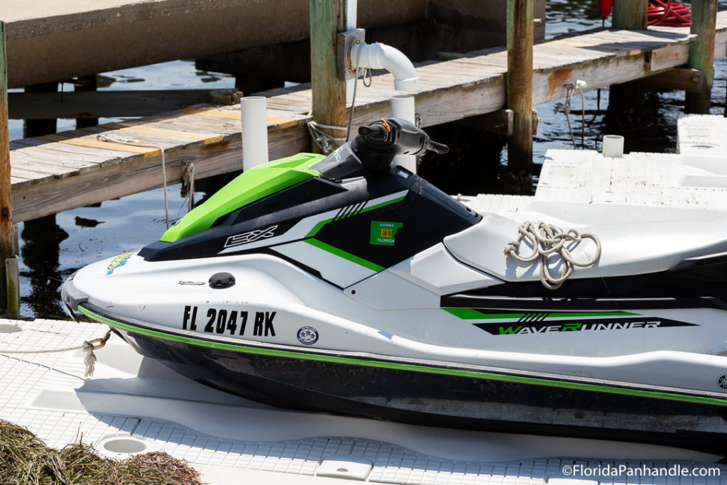 a white, black and lime green jet ski parked on the dock