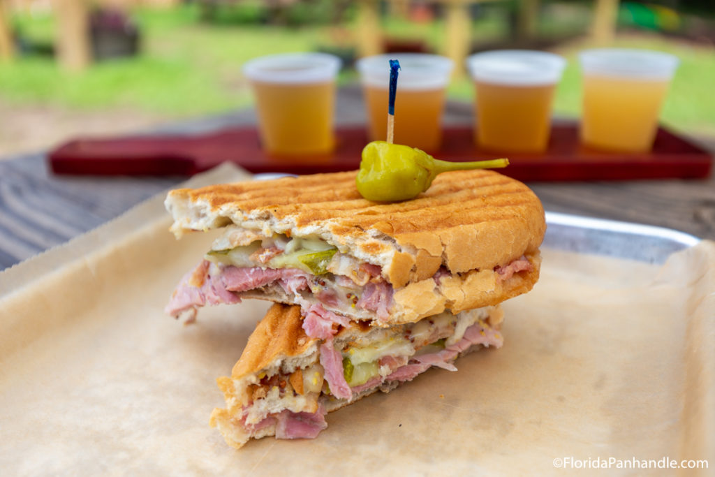 family-friendly brewery, Coastal County Brewing, Pensacola, pressed sandwich with a flight of beers in the background 