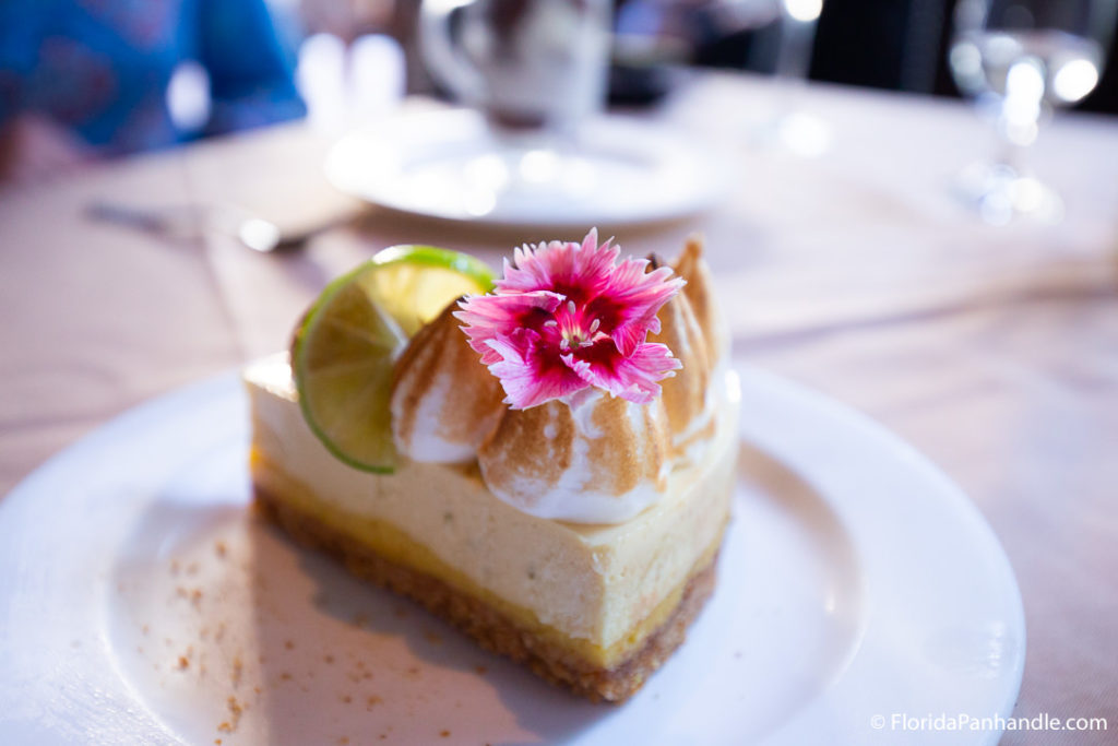 key lime pie with pink flower and lime wheel as garnish