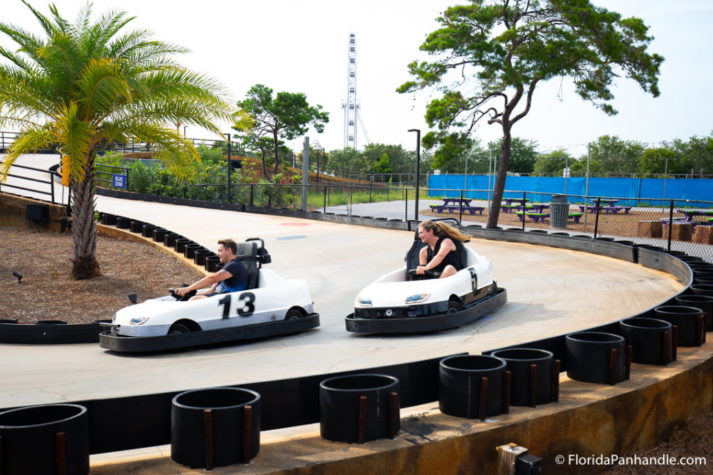 man and woman bumper car racing outside on a race track at Swampy Jack's
