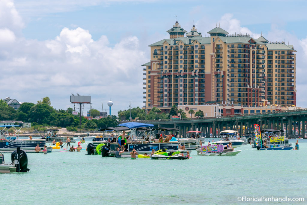 view of destin boardwalk and buildings as well as other boats on top of the water in florida