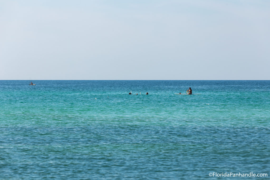 a view of the ocean with swimmers in it