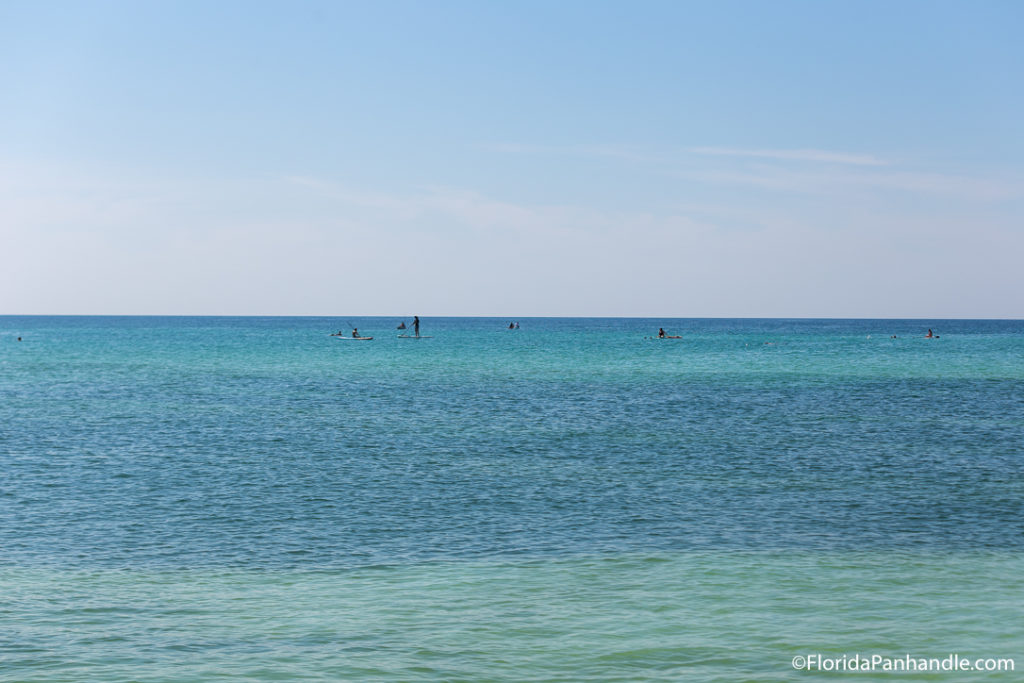 a view of the ocean, beach in pensacola, blue and green waters, blue sky