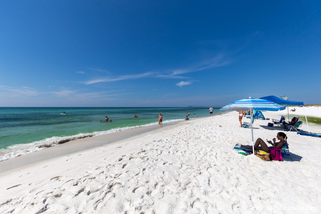 people at the beach and umbrellas in the sand