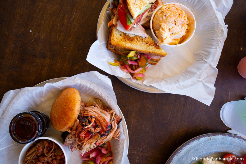 a BBQ pulled pork sandwich with a side of smoked beans and a deli sandwich with a side of potato salad at Water Pig 