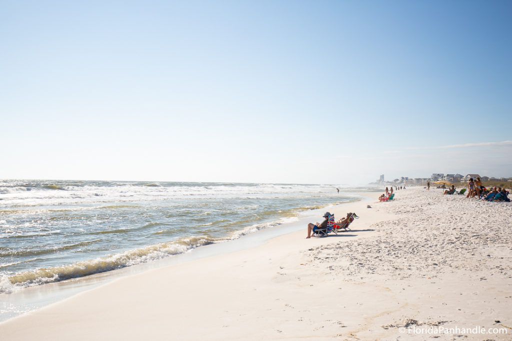 people sunbathing in beach chairs or on the sand at Deer Lake Sate Park in Florida