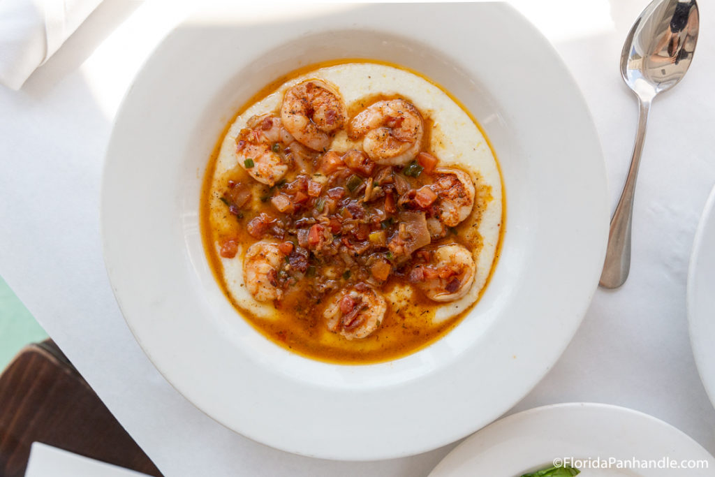 shrimp in bowl with spices on top of it next to spoon at bud and alleys