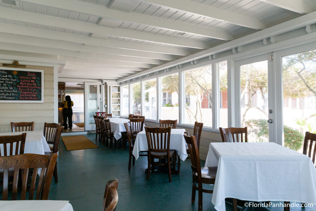 interior of finer dining 30a restaurant with white tablecloth and wooden chairs