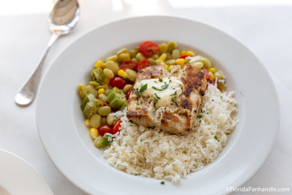 a delicious entree of chicken next to chickpeas salad and rice