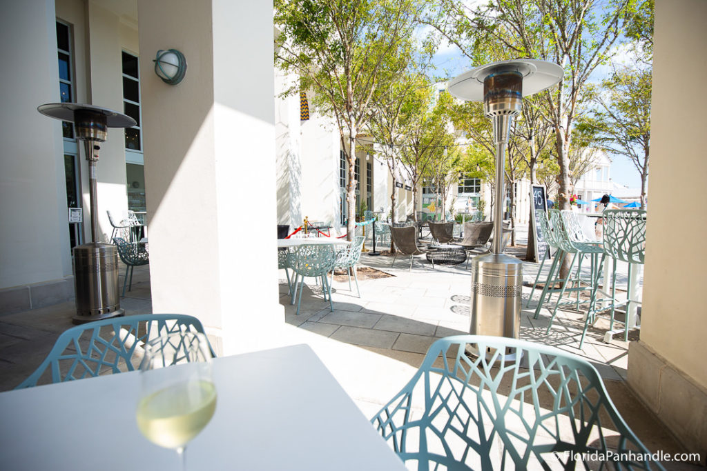an outdoor seating area of a restaurant with white tables and baby blue chairs