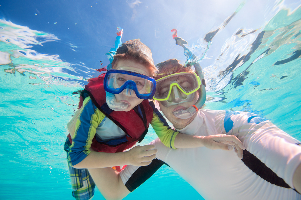 two boys snorkeling under water looking at the camera