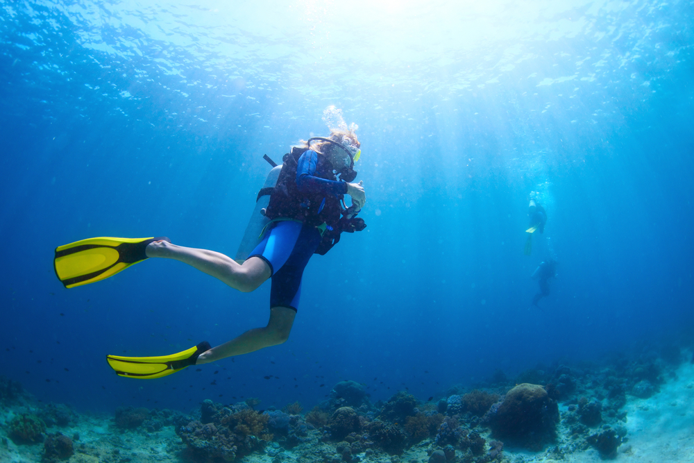 a person free diving in the ocean with yellow fins