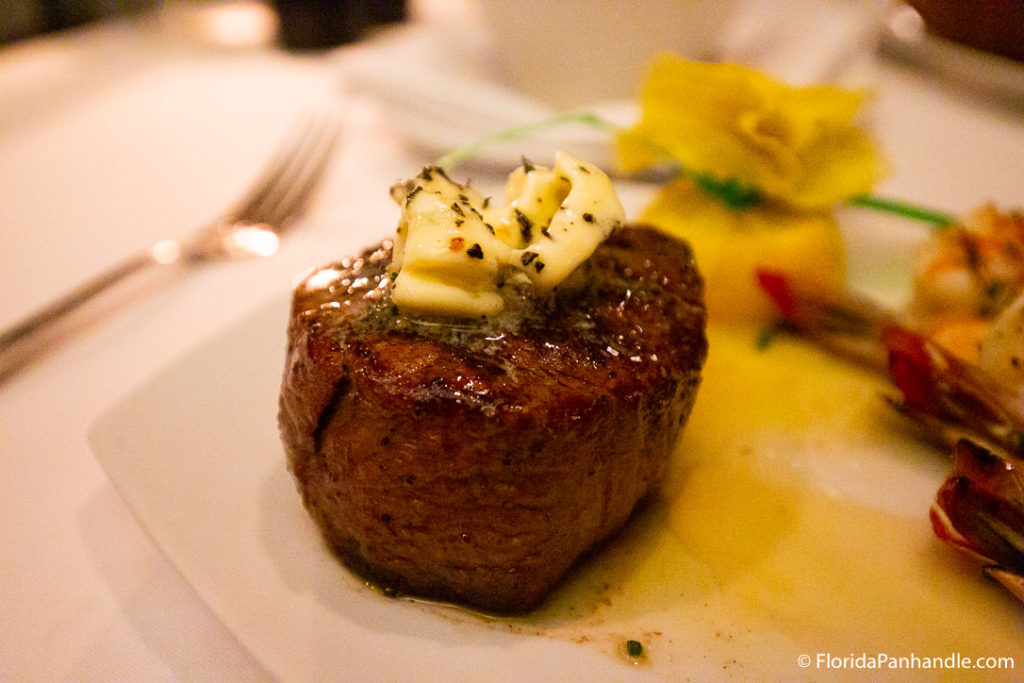 fat filet steak with butter and greens on top at seagar's prime steaks & seafood