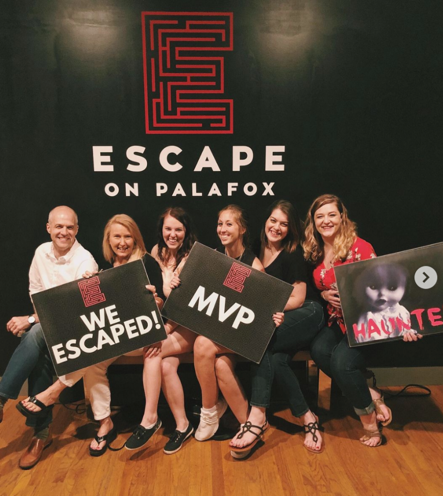 a group of people posing and smiling at Escape on Palafox in Pensacola Florida