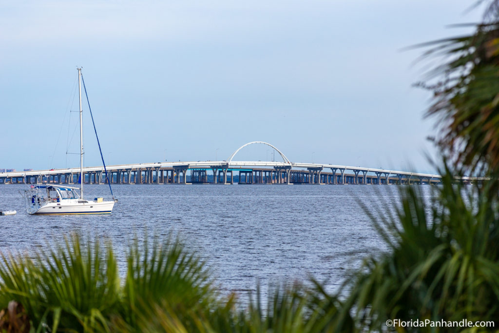 pensacola bay bridge in the background with boat in forefront and grass leaves