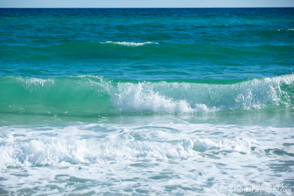 picture of light turquoise water crashing back into itself in the form of a wave