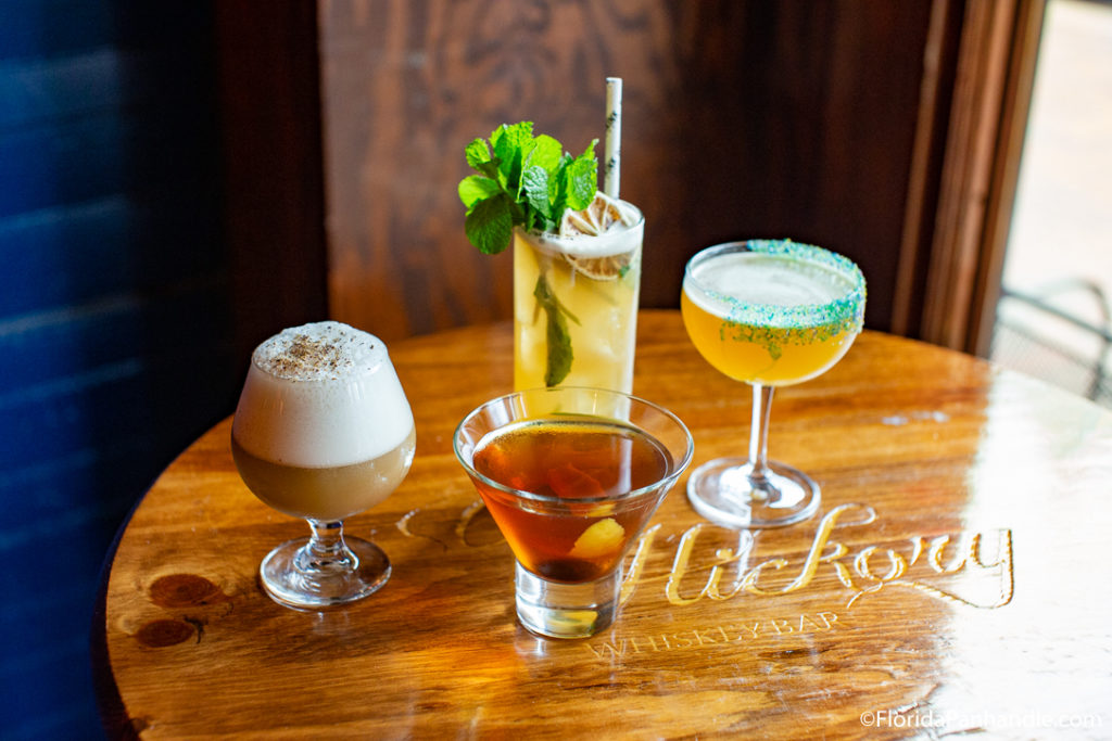 four drinks on top of hickory whiskey bar table in pensacola