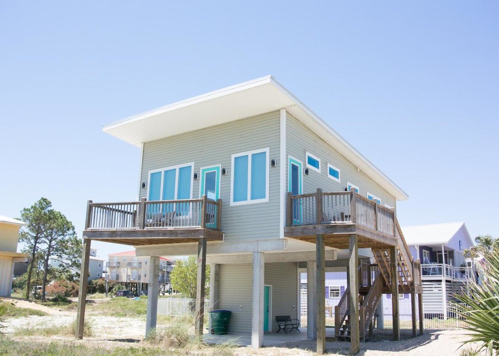beach front condo with wooden deck and teal blue door outline